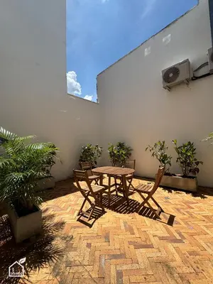a patio with a table and chairs and plants at Ecohousing in Medellín