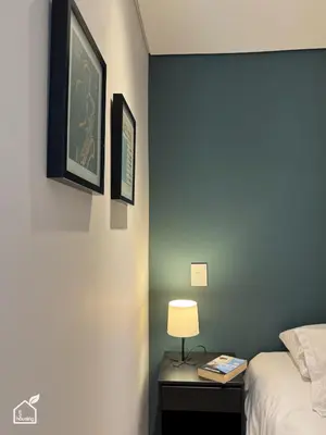 a bedroom with a bed and a lamp on a nightstand at Ecohousing in Medellín