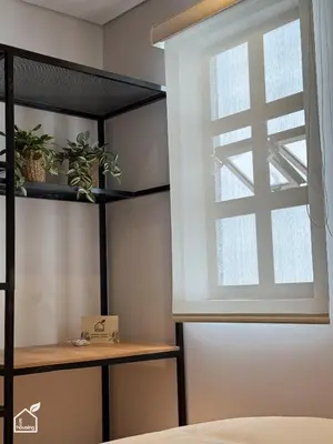 a window in a bedroom with a bed and a shelf at Ecohousing in Medellín