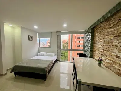 a bedroom with a bed and a brick wall at Magnificent apartment near Lleras and Provenza in Medellín