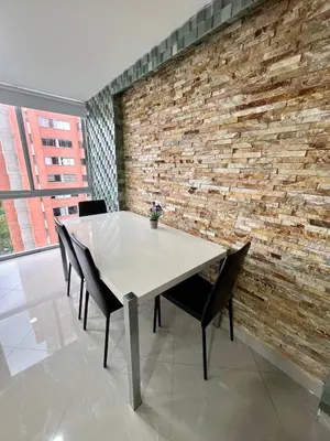 a table and chairs in a room with a brick wall at Magnificent apartment near Lleras and Provenza in Medellín