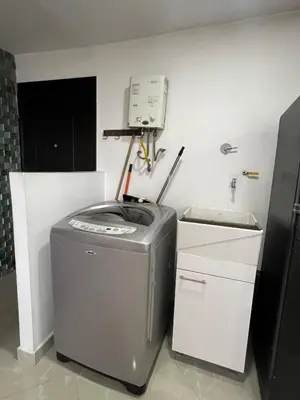 a small kitchen with a refrigerator and a trash can at Magnificent apartment near Lleras and Provenza in Medellín