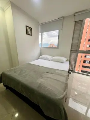 a bedroom with a large bed with a window at Magnificent apartment near Lleras and Provenza in Medellín