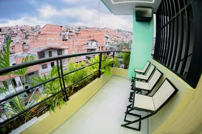 a balcony with chairs and a view of a city at Live the Comuna 13 experience in Medellín INT 304 in Medellín
