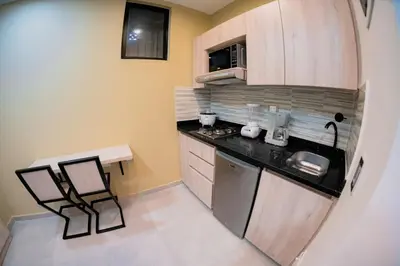 a small kitchen with a sink and a microwave at Live the Comuna 13 experience in Medellín INT 305 in Medellín