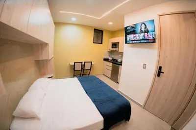 a small bedroom with a bed and a television at Live the Comuna 13 experience in Medellín INT 305 in Medellín