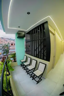 a balcony with four chairs on a building at Experience Medellín's Comuna 13 INT401 in Medellín