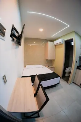 a small room with a bed and a table at Experience Medellín's Comuna 13 INT401 in Medellín