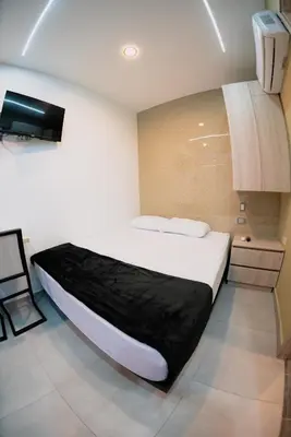 a bedroom with a bed and a tv on the wall at Experience Medellín's Comuna 13 INT401 in Medellín