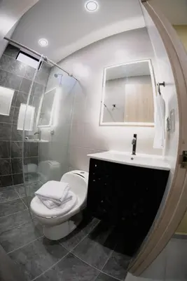 a bathroom with a toilet and a sink and a mirror at Experience Medellín's Comuna 13 INT401 in Medellín