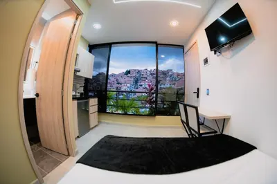 a bedroom with a bed and a large window at Experience Medellín's Comuna 13 INT401 in Medellín