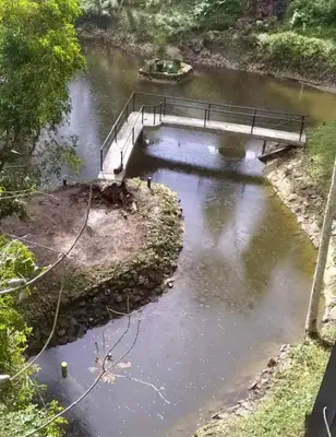 a bridge over a river with a bridge in the water at Cabaña Del Lago - Cerca Metrocable ARVI in Guarne