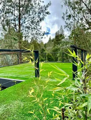 a view of a tennis court with green grass at Cabaña Del Lago - Cerca Metrocable ARVI in Guarne