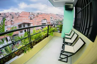 a balcony with chairs and a view of a city at vive la experiencia comuna 13 Medellín INT 304 in Medellín