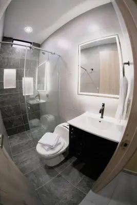 a bathroom with a toilet and a sink and a mirror at vive la experiencia comuna 13 Medellín INT 304 in Medellín