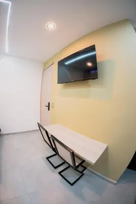 a room with a table and a tv on the wall at vive la experiencia comuna 13 Medellín INT 304 in Medellín
