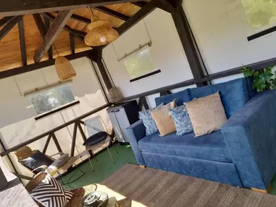 a living room with a blue couch and chairs at Cabaña Blanca Cielo Abierto in Guarne