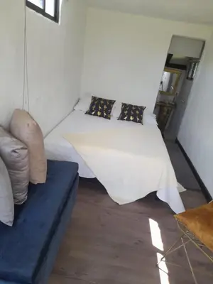a bedroom with a bed and a couch at Cabaña Blanca Cielo Abierto in Guarne