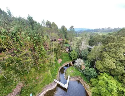 an aerial view of a bridge over a river at Cabaña en el Lago Cerca MetroCable ARVI in Guarne