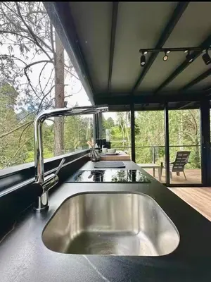 a kitchen with a sink and a large window at Cabaña en el Lago Cerca MetroCable ARVI in Guarne