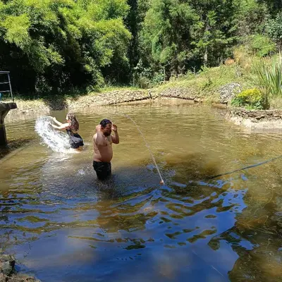 a couple of people in a river with a rope at Cabaña en el Lago Cerca MetroCable ARVI in Guarne