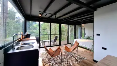 a kitchen with a sink and two chairs in a room at Cabaña en el Lago Cerca MetroCable ARVI in Guarne