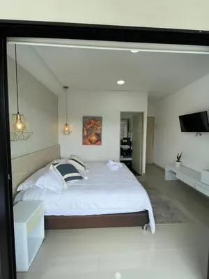 a bedroom with a large bed and a flat screen tv at Casa Hotel Spa Carolina in Carolina del Principe