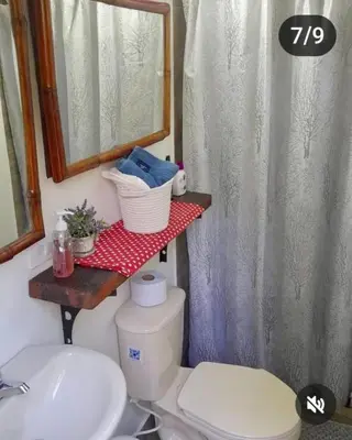 a bathroom with a toilet and a sink and a mirror at Refugio en el Árbol in Guarne