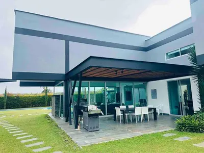 a house with a patio with a table and chairs at Country house near the airport and Medellin in El Retiro