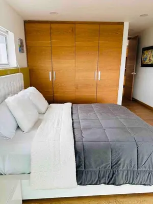 a bedroom with a large bed with wooden cabinets at Country house near the airport and Medellin in El Retiro