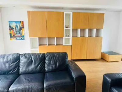 a living room with a black leather couch and wooden cabinets at Country house near the airport and Medellin in El Retiro