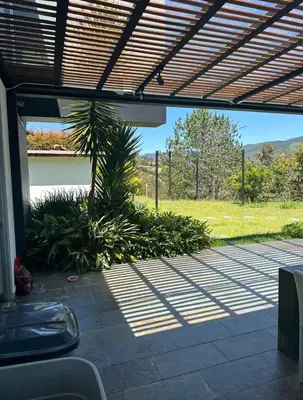 an open patio with a palm tree and a fence at Villa near the airport and Medellin in El Retiro