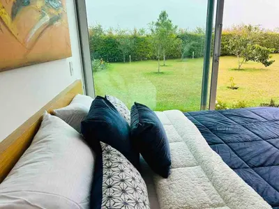 a bedroom with a couch and a large window at Villa near the airport and Medellin in El Retiro
