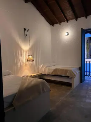 a bedroom with two beds and a light on the wall at Casa La Oronda - Hotel Boutique- Cauca Viejo in Jericó