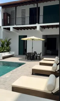a pool with lounge chairs and an umbrella next to a house at Casa La Oronda - Hotel Boutique- Cauca Viejo in Jericó