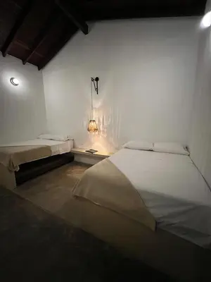 a bedroom with two beds and a light on the wall at Casa La Oronda - Hotel Boutique- Cauca Viejo in Jericó
