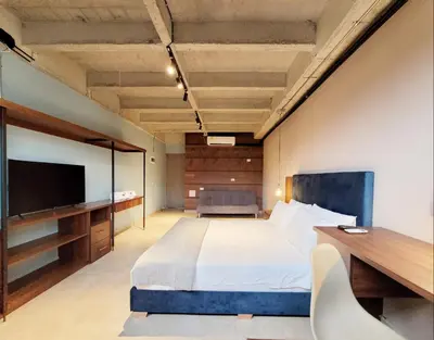 a bedroom with a bed and a desk and a tv at The Hub by Wynwood House in Medellín