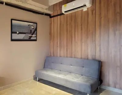 a blue couch in a room with a wall at The Hub by Wynwood House in Medellín