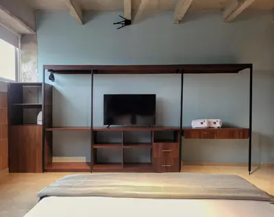 a bedroom with a bed with a tv on a wall at The Hub by Wynwood House in Medellín