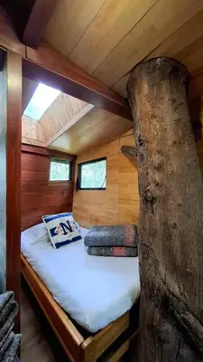a bedroom in a tree house with a bed at Casa en el Arbol - Cerca Metrocable ARVI - Camping in Guarne