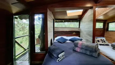 a bed in the back of a tiny house at Casa en el Arbol - Cerca Metrocable ARVI - Camping in Guarne