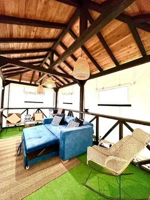 a living room with a blue couch and chairs at Cabaña Blanca Guarne cerca a Metrocable ARVI in Guarne