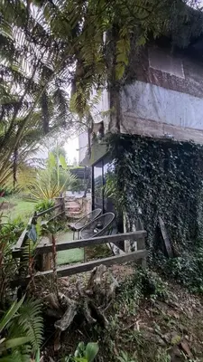 a bench in front of a building with vines at Cabaña Blanca Guarne cerca a Metrocable ARVI in Guarne