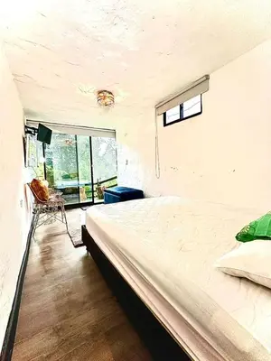 a bedroom with a large bed and a window at Cabaña Blanca Guarne cerca a Metrocable ARVI in Guarne