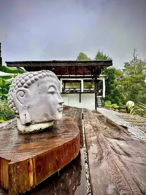 a statue of a head sitting on top of a table at Cabaña Blanca Guarne cerca a Metrocable ARVI in Guarne