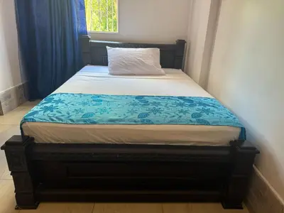 a bed in a bedroom with a blue and white blanket at Angel Mari a Doradal in Doradal