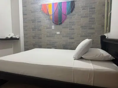 a bed with two pillows and a brick wall at Angel Mari a Doradal in Doradal