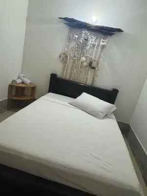 a bedroom with a bed with white sheets and a clock at Angel Mari a Doradal in Doradal