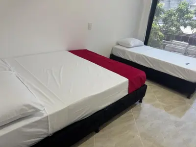 two beds in a room with a window at Angel Mari a Doradal in Doradal