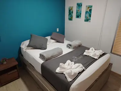 a bedroom with a bed with towels on it at Frente al Malecón con Vista, Zona Gastronómica, PARQUEDERO GRATIS in Guatapé